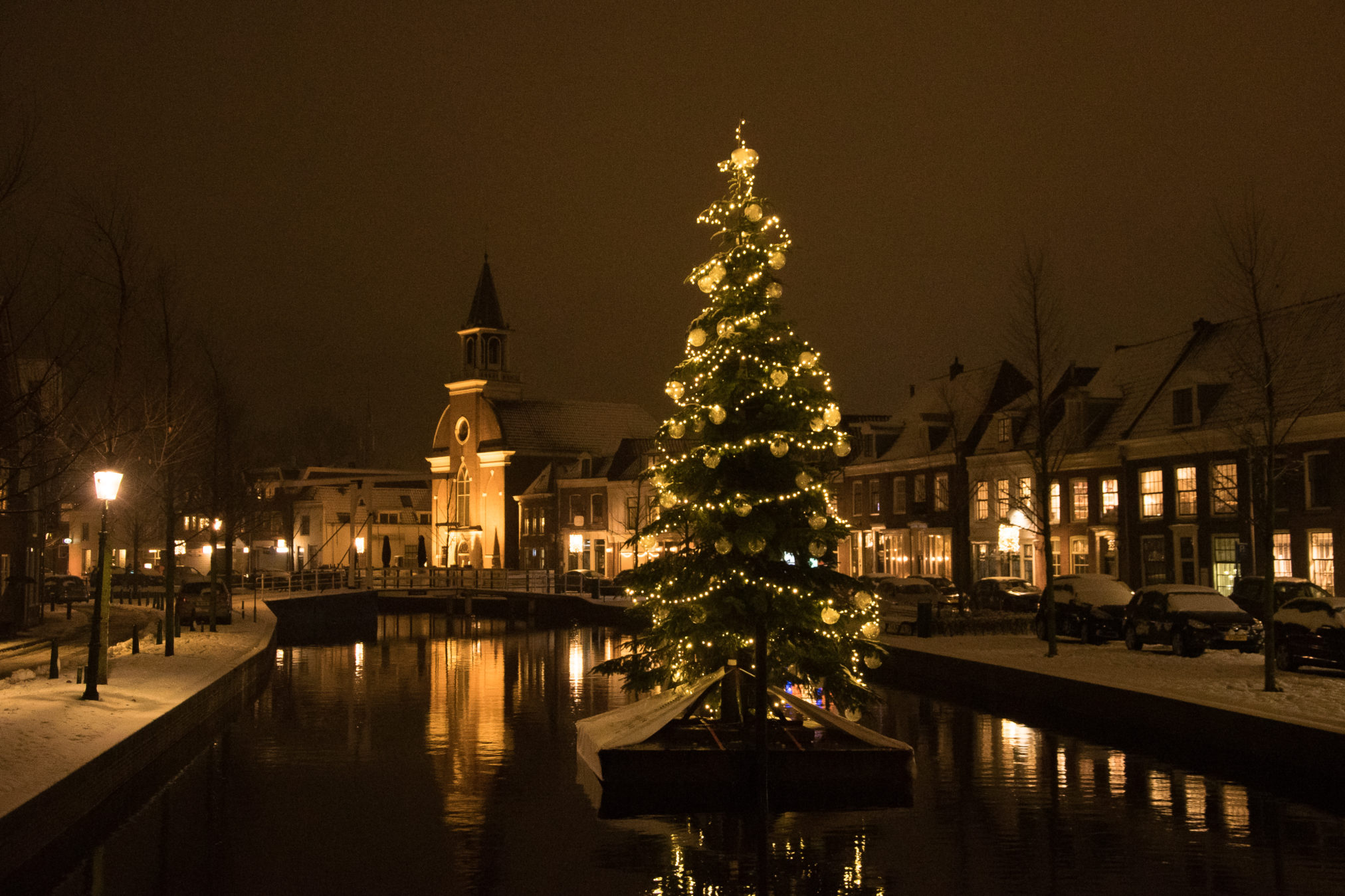 De Oudegracht in Weesp met sneeuw en kerstboom op ponton.
