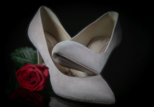 Foto van de schoenen van de bruid met roos