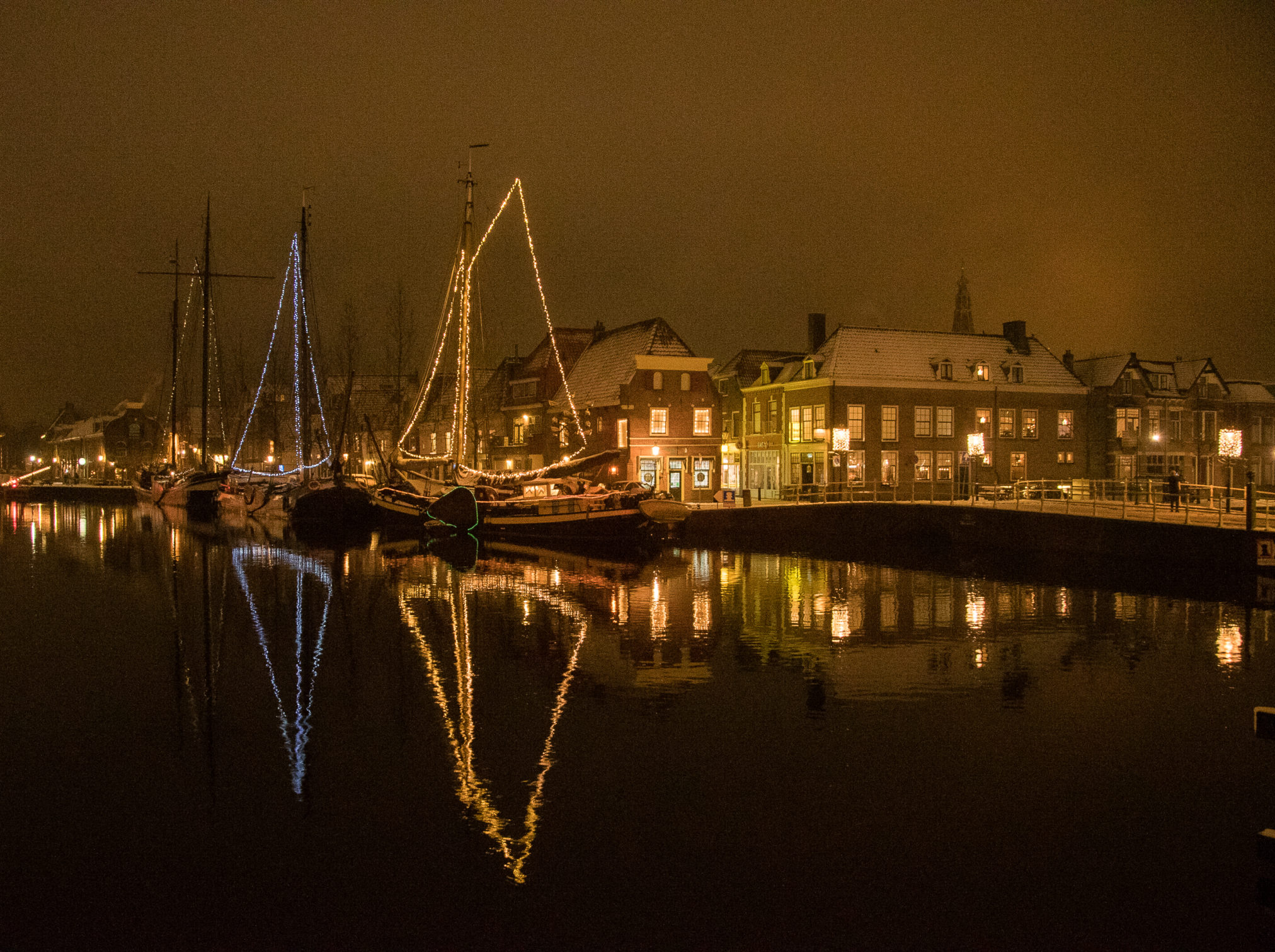 De kom van Weesp met verlichte schepen gefotografeerd in de wintermaanden met sneeuw bedekt.
